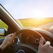 Individual driving a car on the road.